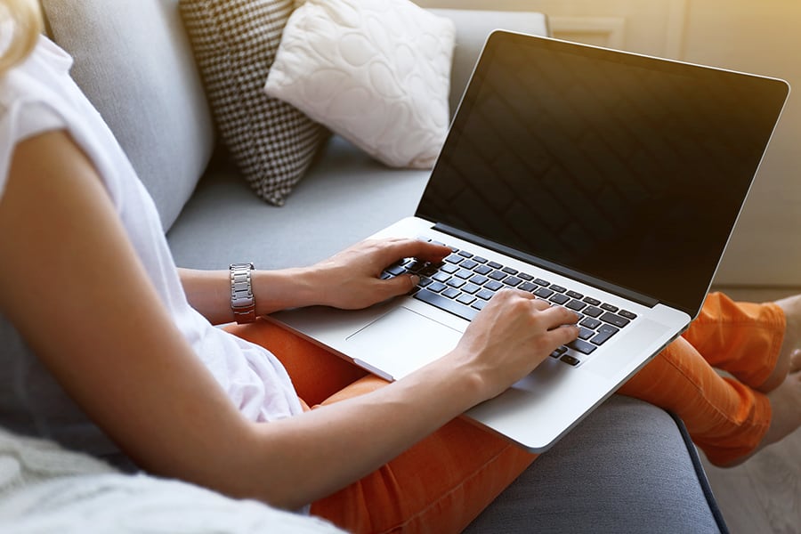 A woman using a laptop to create a fake ultrasound online