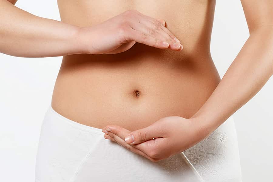 A woman outlines her stomach with her hands
