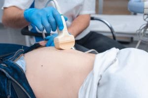 Doctor with blue gloves performs an ultrasound