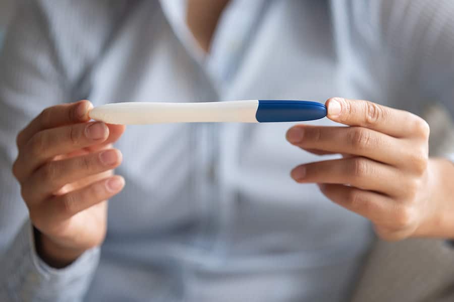 A woman balances a pregnancy test