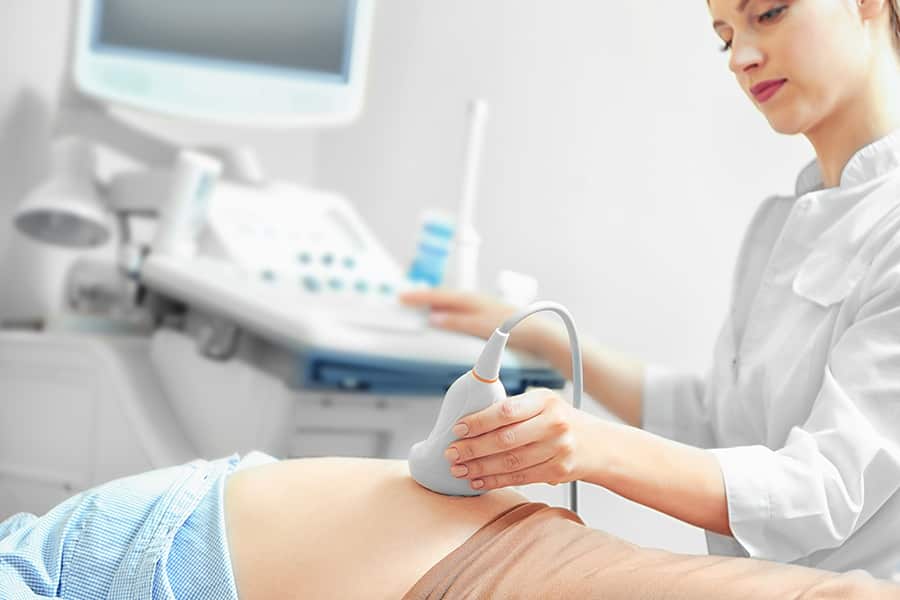 Woman doctor uses an ultrasound machine