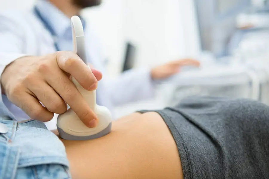 Man doctor uses an ultrasound machine