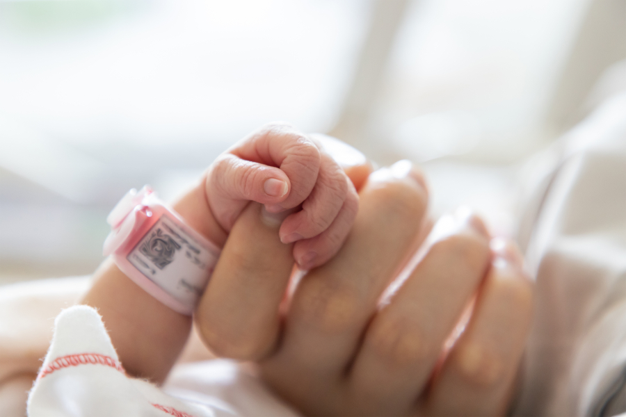 Newborn holding mom's finger