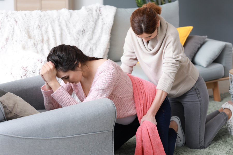 An aide helps a pregnant woman with a massage