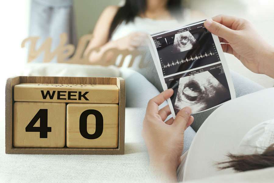 A woman holding an ultrasound at 40 weeks