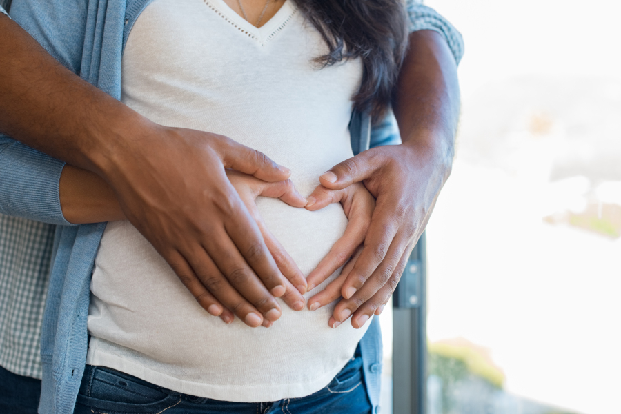 Man and woman heart hands on stomach