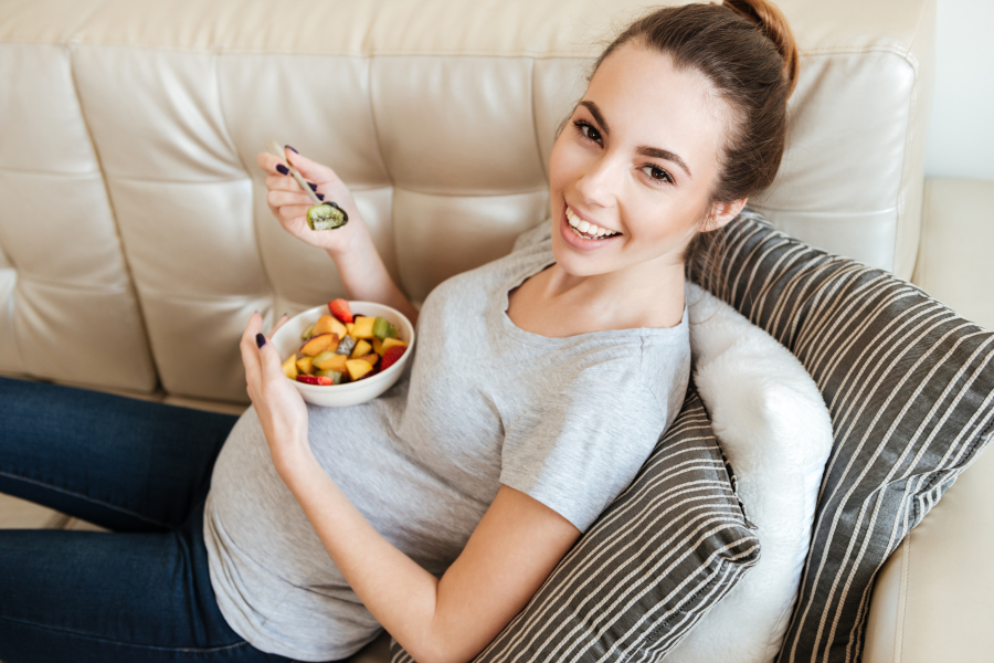 Pregnant woman eating on a couch