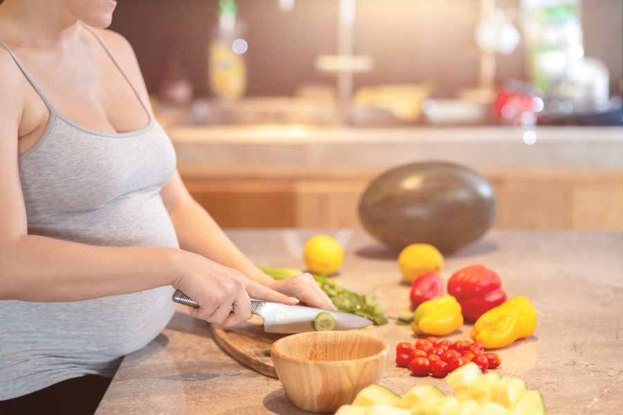 Pregnant woman cutting food
