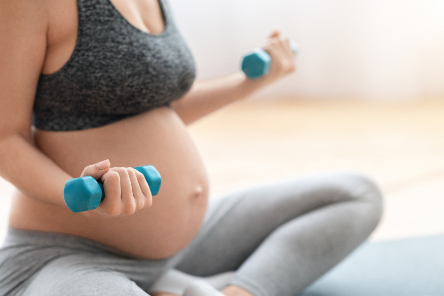 A pregnant woman using weights