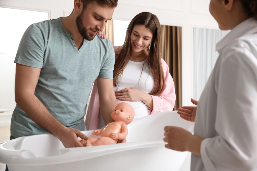 A pregnant couple learning how give a bath