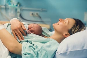 A mother holding a newborn in the hospital
