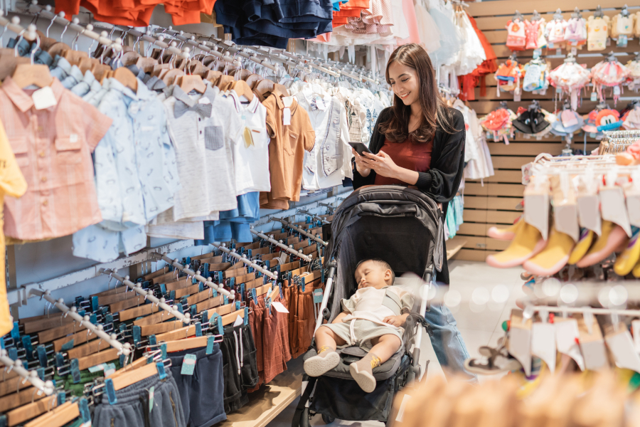 A woman and a baby in a stroller shopping
