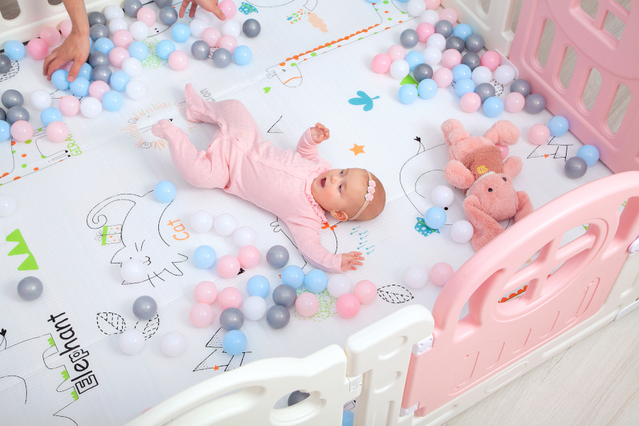 A baby laying in a playpen