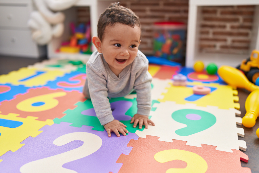 Baby crawls on a play mat